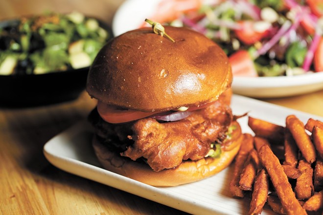 The waffle chicken sandwich, shown here with a side of sweet potato fries, is an early favorite at Bark, A Rescue Pub.