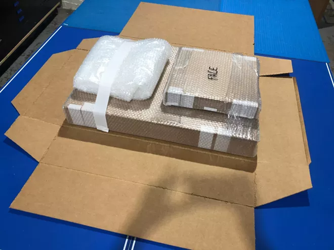 An unfolded box of various artworks packed for shipping.